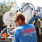 Fotografia operaio della ditta al lavoro con il camion per spurghi